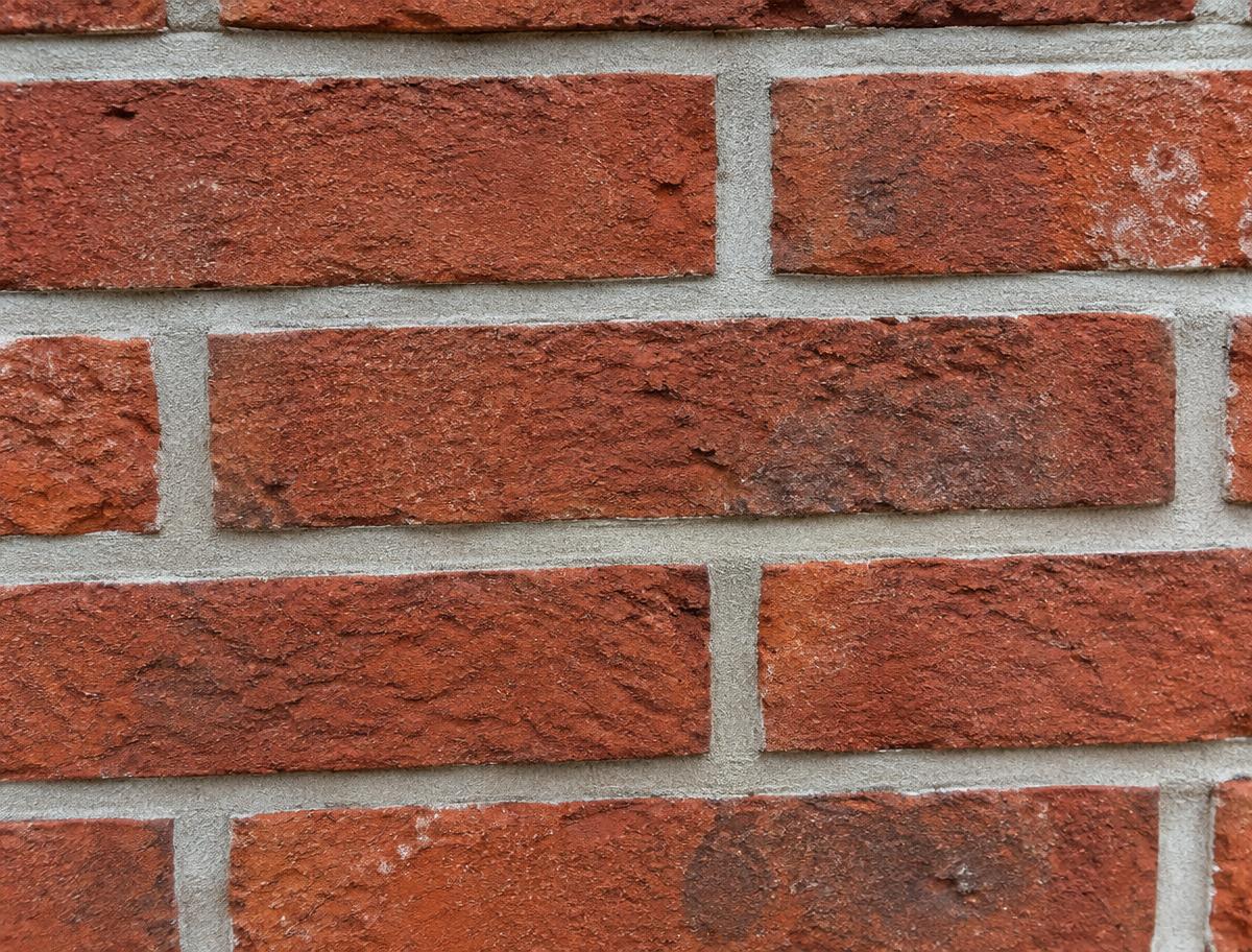 Detail van strak nieuw voegwerk tussen rode bakstenen