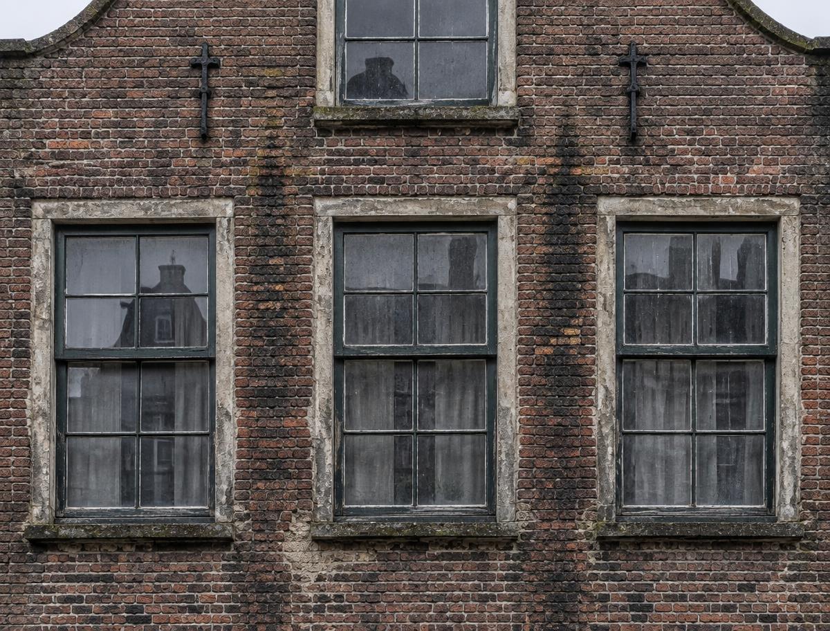 Gevel voor renovatie: vervuild metselwerk met aangetast voegwerk